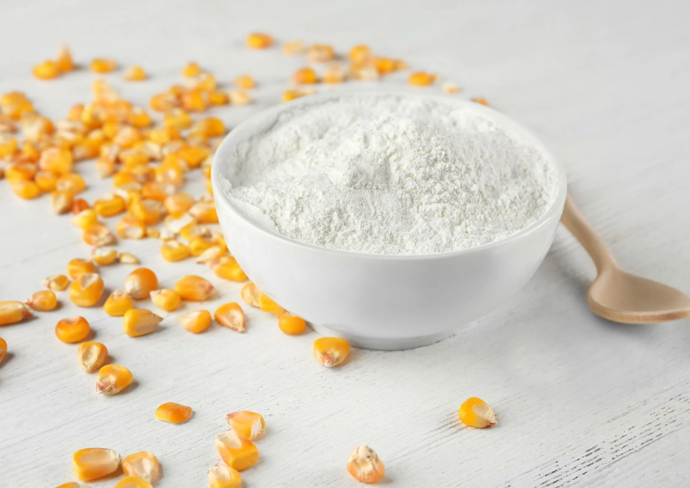 Corn syrup solids in white bowl with corn kernels