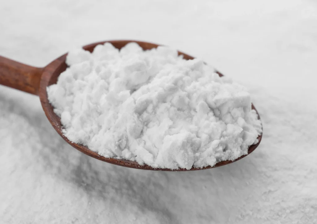 Wooden spoon scooping glucose syrup solids